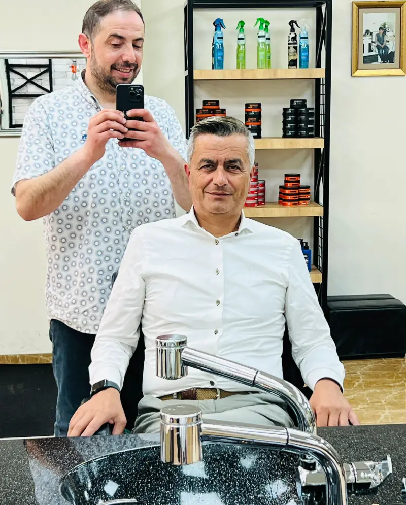 Oguz maakt via de spiegel een foto van een tevreden klant